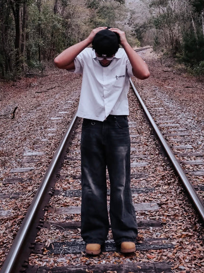 Jesus Is King Boxy Shirt worn open on railroad tracks, front