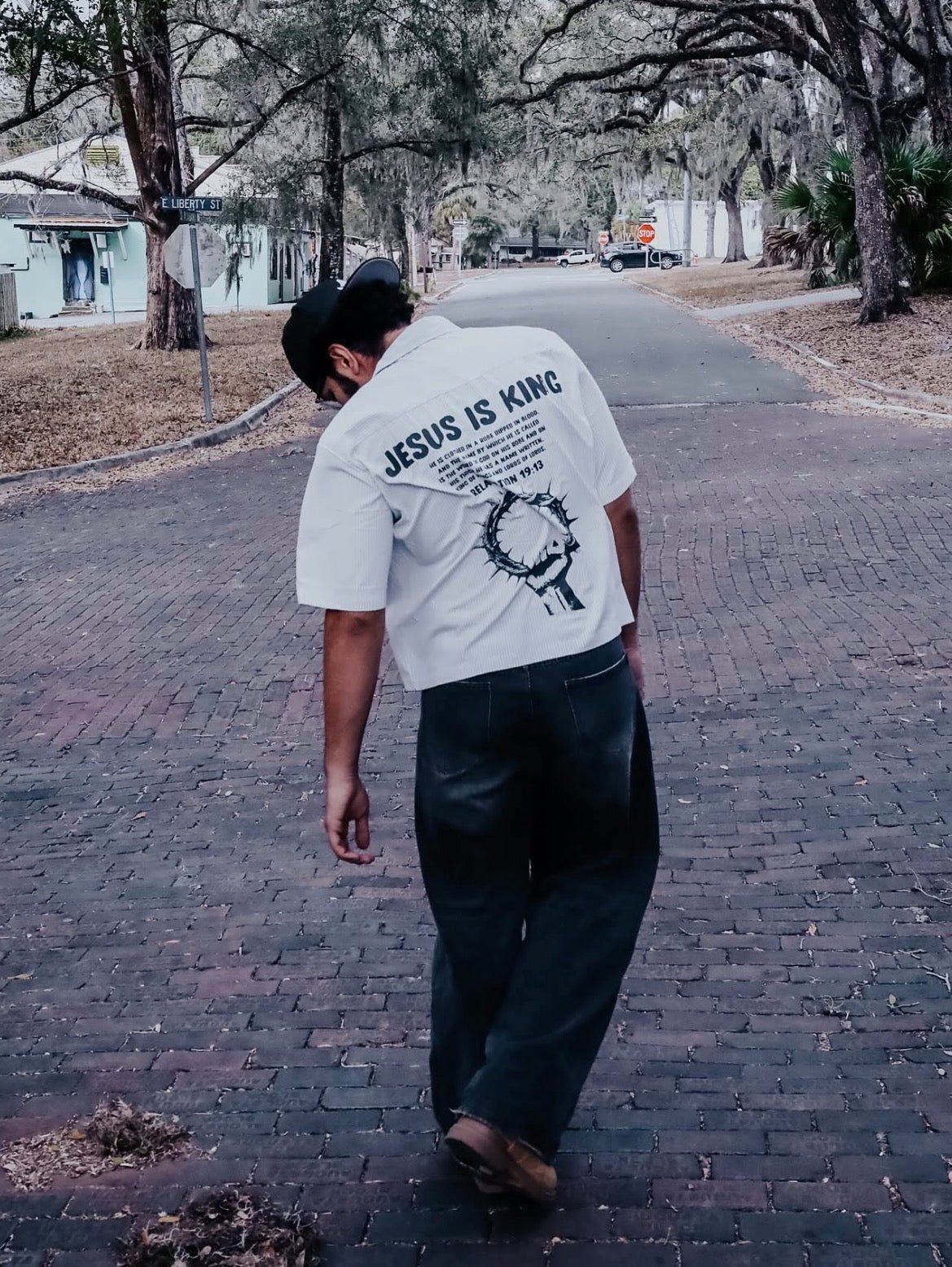 Jesus Is King Boxy Shirt worn on a brick street, back print visible