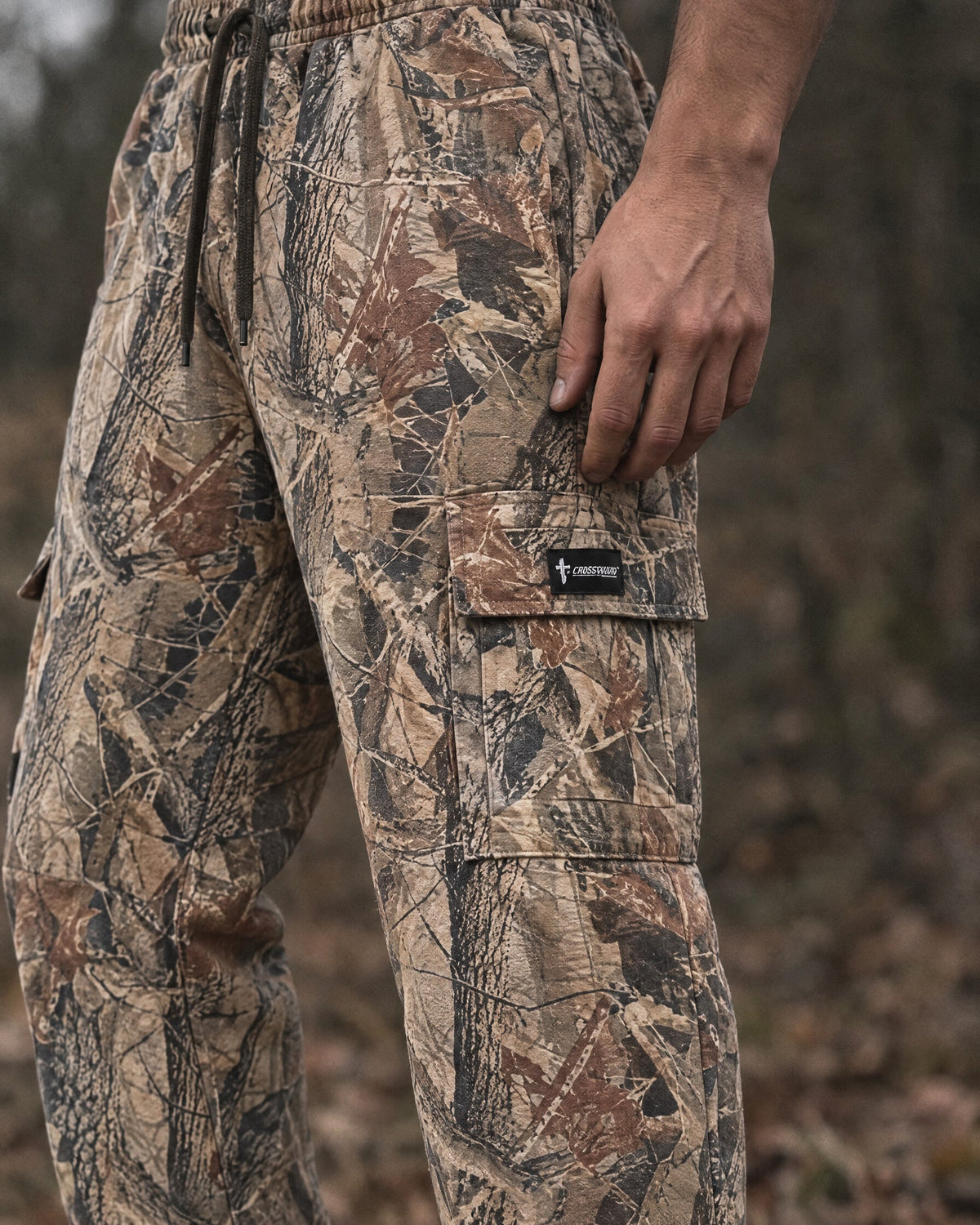 Crossway camo cargo sweatpants, close detail of the thigh cargo pocket and woven label