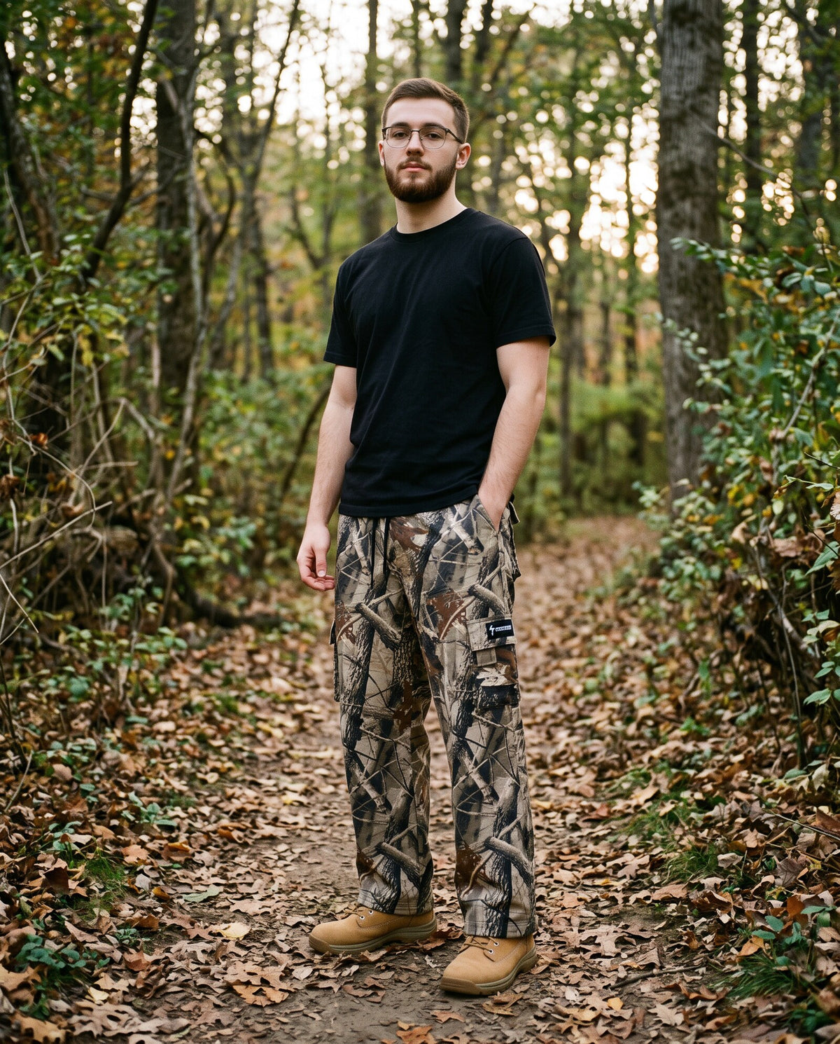 Young man in Crossway Kingdom Camo cargo sweatpants on a wooded trail